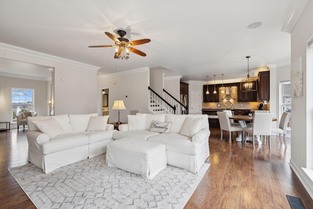 living room featuring wood-type flooring, ornamental molding, and ceiling fan