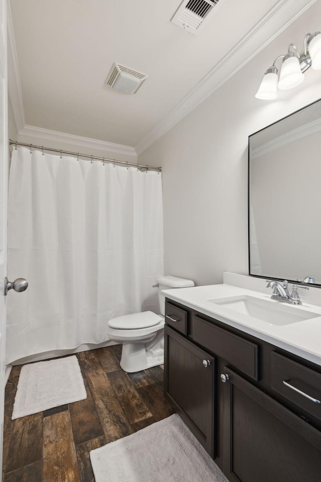 bathroom with vanity, hardwood / wood-style flooring, ornamental molding, and toilet