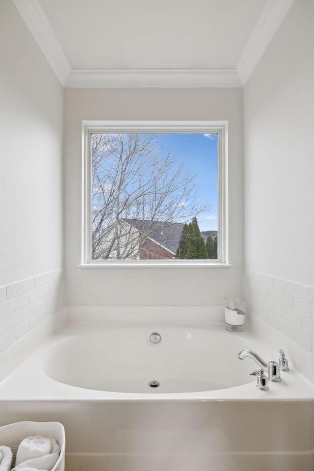 bathroom with a tub to relax in and crown molding