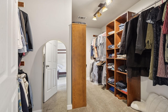 walk in closet featuring light colored carpet