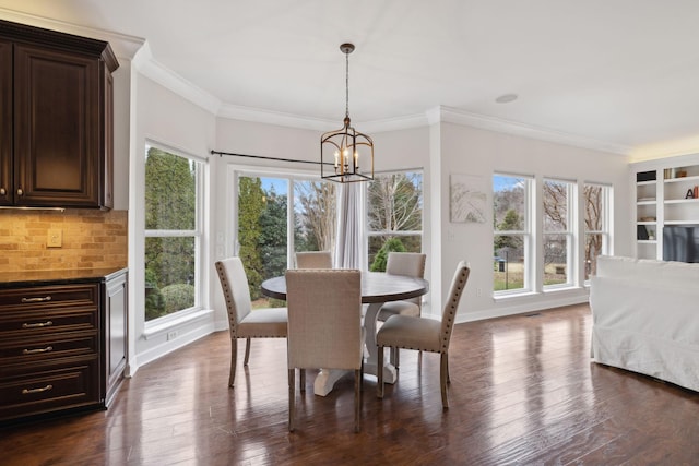 dining space with a notable chandelier, ornamental molding, and dark hardwood / wood-style floors