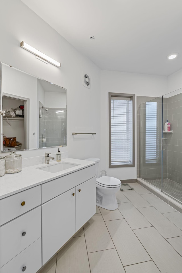 bathroom featuring vanity, an enclosed shower, and toilet