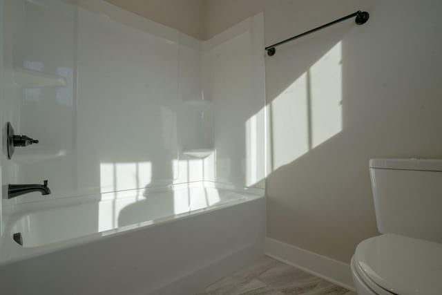 bathroom featuring bathtub / shower combination and toilet