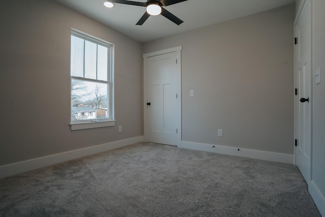 unfurnished bedroom with ceiling fan and light colored carpet