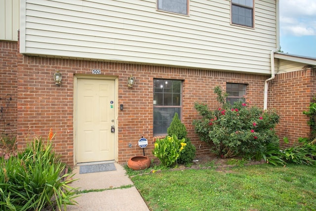 doorway to property with a lawn