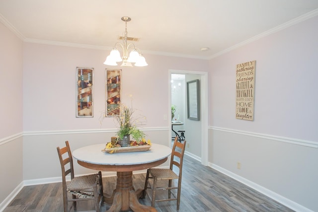 dining room featuring ornamental molding, an inviting chandelier, and dark hardwood / wood-style flooring