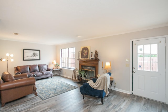 living room with ornamental molding and light hardwood / wood-style flooring