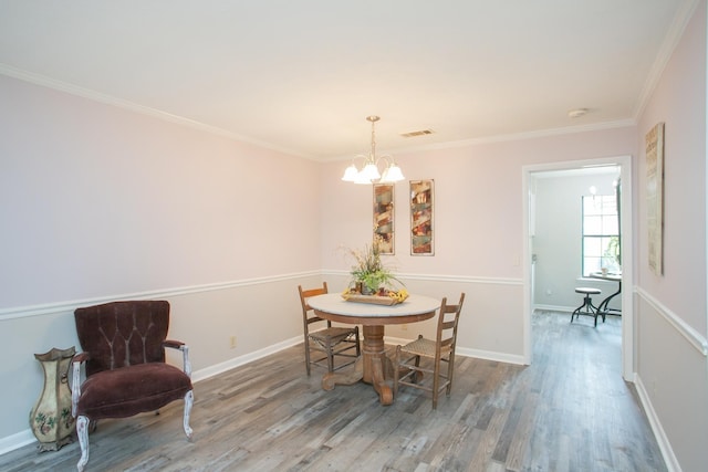 dining area with a notable chandelier, hardwood / wood-style flooring, and ornamental molding