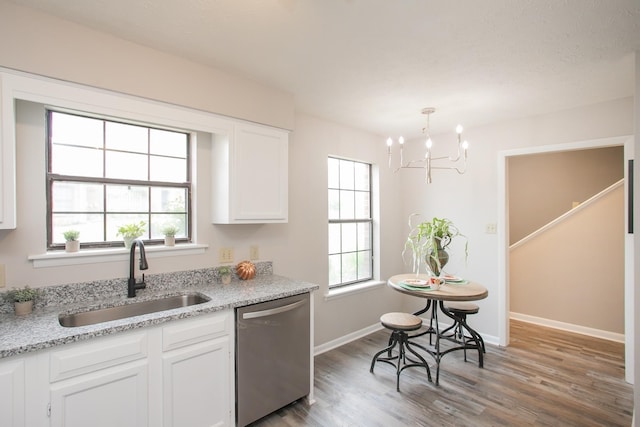 kitchen with light stone counters, stainless steel dishwasher, sink, and white cabinets