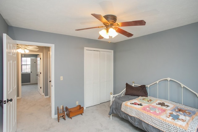 carpeted bedroom featuring ceiling fan and a closet