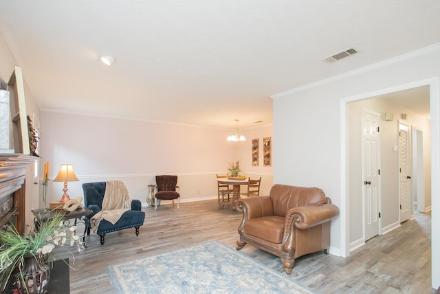 living area with crown molding, a notable chandelier, and light hardwood / wood-style flooring