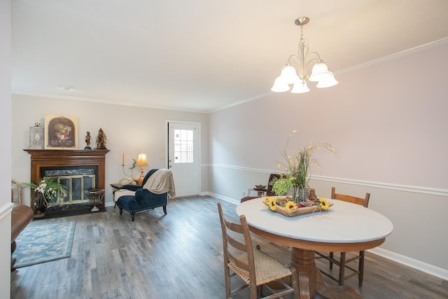 dining room featuring dark wood-type flooring, crown molding, and a chandelier