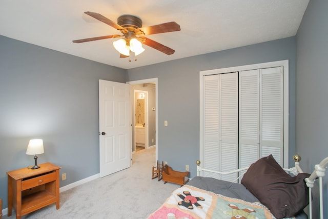 bedroom featuring light colored carpet, a closet, and ceiling fan