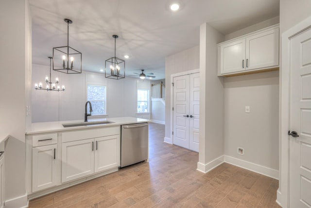 kitchen with hanging light fixtures, white cabinetry, sink, and stainless steel dishwasher