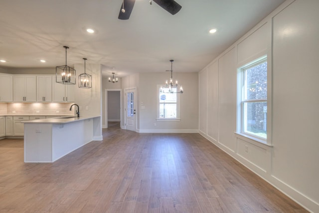 kitchen with white cabinetry, sink, tasteful backsplash, and pendant lighting