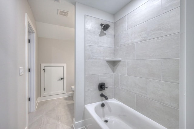 bathroom with toilet and tiled shower / bath