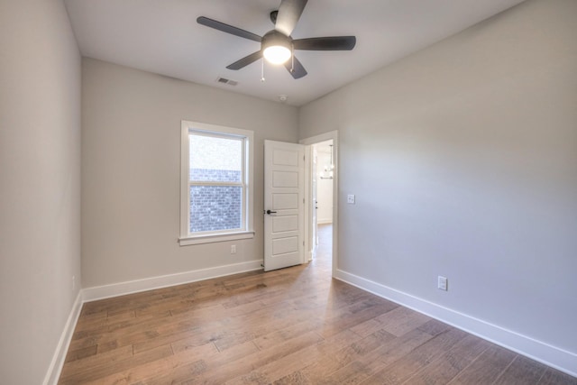 spare room with hardwood / wood-style floors and ceiling fan