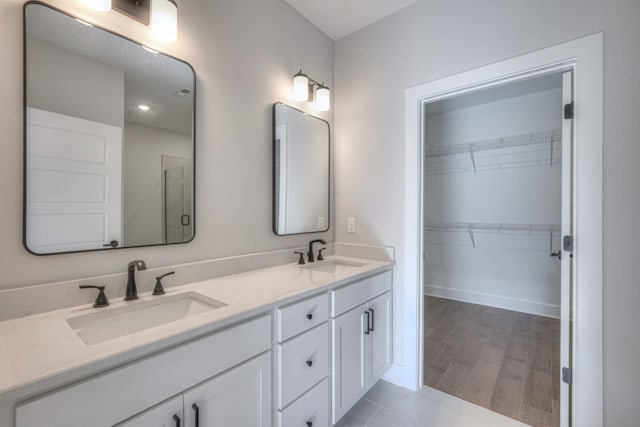 bathroom with vanity, a shower with shower door, and hardwood / wood-style floors