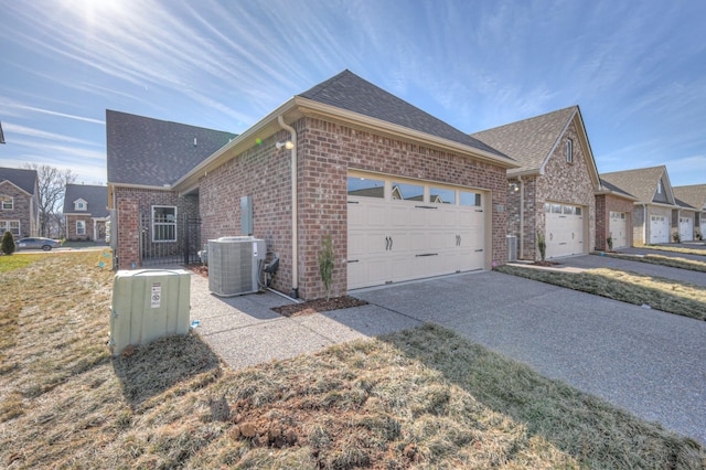 view of side of home with a garage, a lawn, and central air condition unit