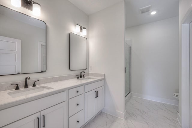 bathroom with vanity, a shower with door, and toilet