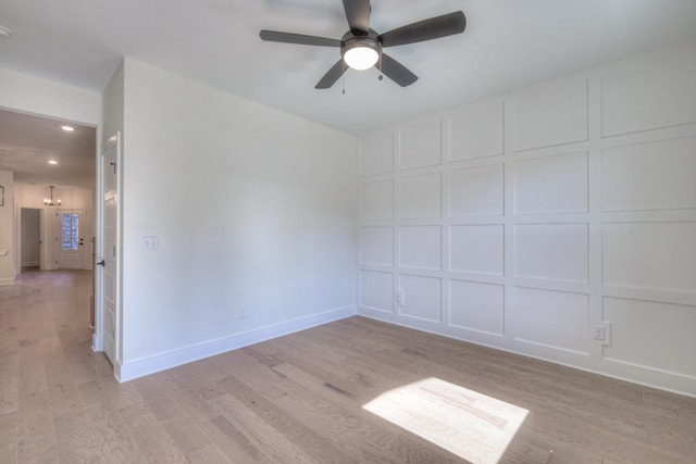 empty room with ceiling fan and light hardwood / wood-style flooring