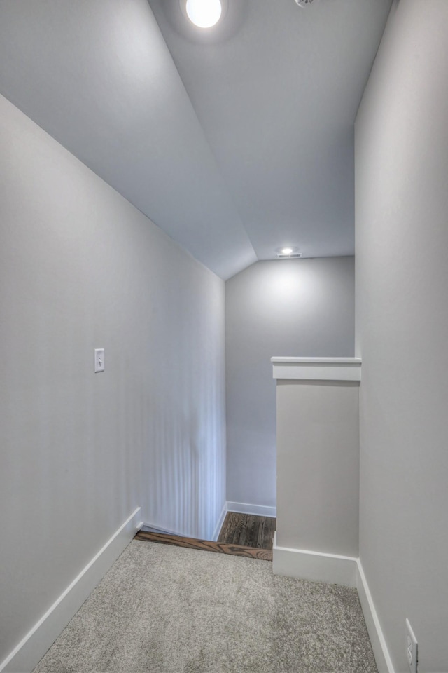 unfurnished room featuring vaulted ceiling and carpet