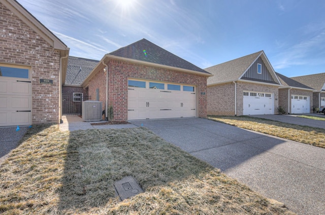 view of front of home featuring a garage, a front lawn, and central air condition unit