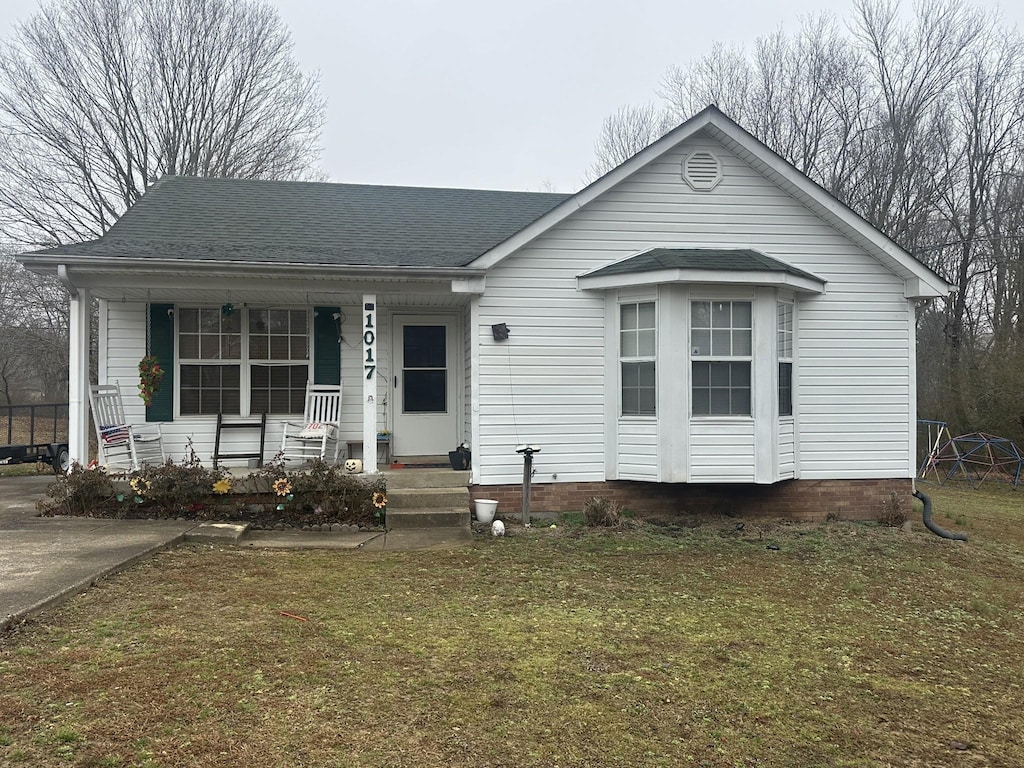 bungalow-style house with a front yard and covered porch