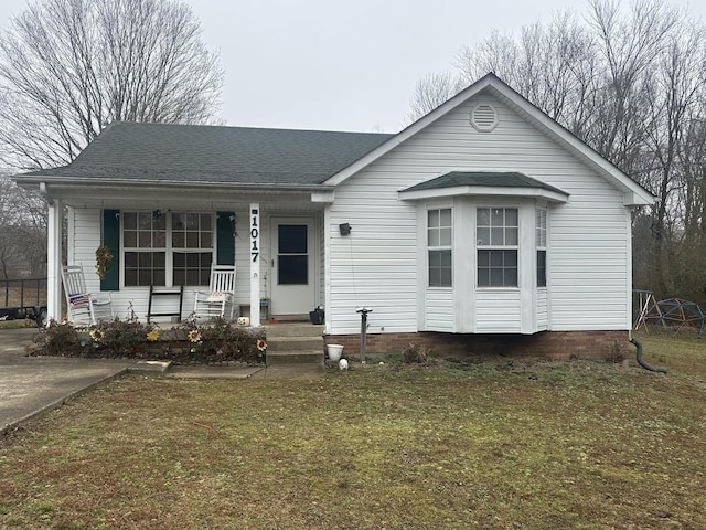 bungalow-style house with a front yard and covered porch