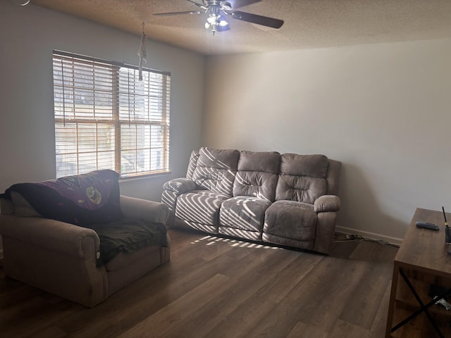 living room with ceiling fan, dark hardwood / wood-style floors, and a textured ceiling