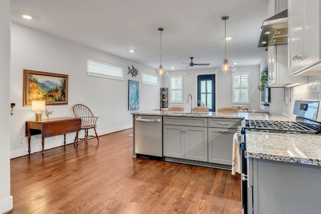 kitchen featuring pendant lighting, sink, gray cabinetry, light stone counters, and stainless steel appliances