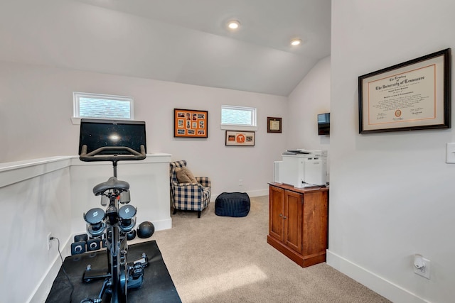 exercise room featuring light colored carpet, lofted ceiling, and plenty of natural light