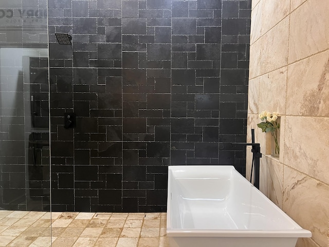 bathroom with a tile shower and tile walls