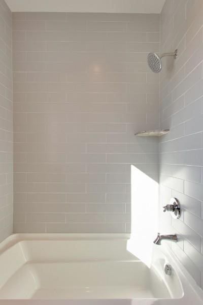 bathroom featuring tiled shower / bath