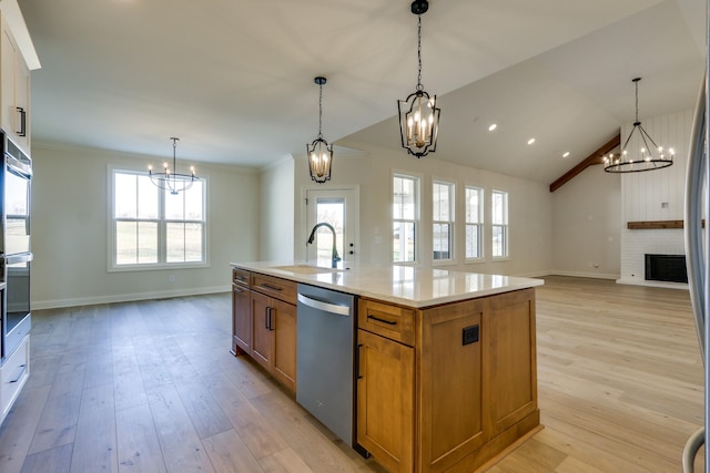 kitchen featuring appliances with stainless steel finishes, hanging light fixtures, and a center island with sink