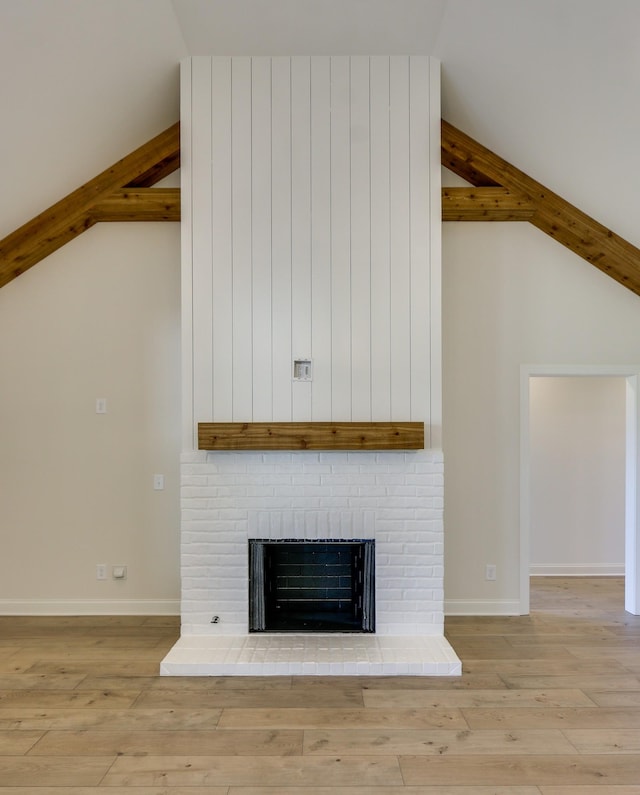 room details featuring hardwood / wood-style floors, beamed ceiling, and a brick fireplace