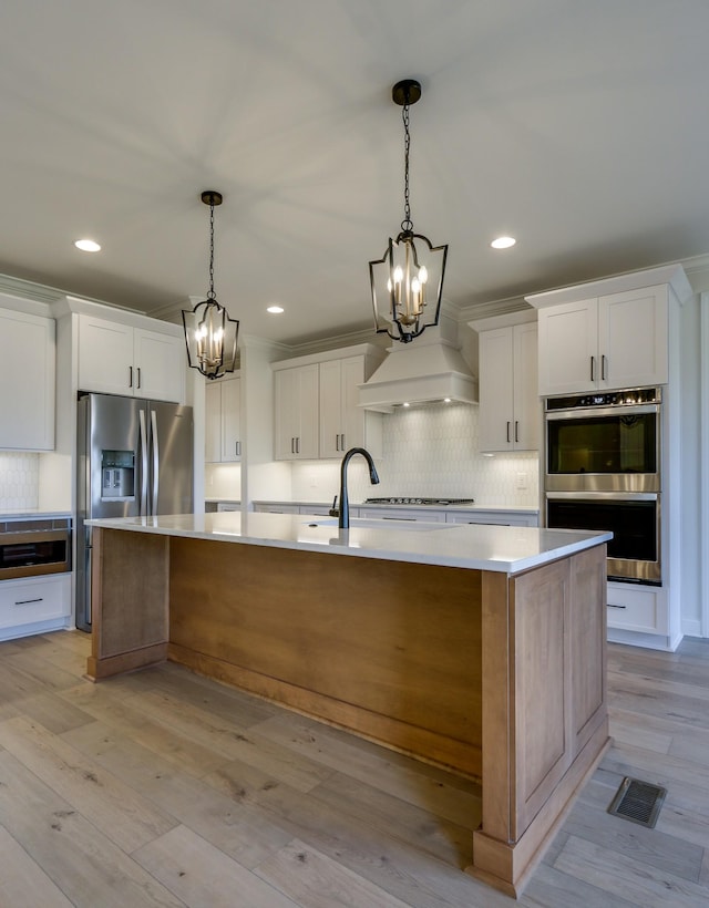 kitchen featuring a large island, white cabinetry, and pendant lighting