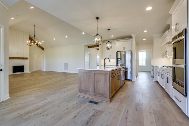 kitchen with white cabinetry, a chandelier, appliances with stainless steel finishes, pendant lighting, and a large island