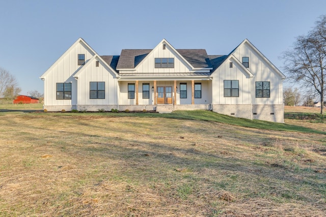 modern farmhouse style home with a front yard and covered porch