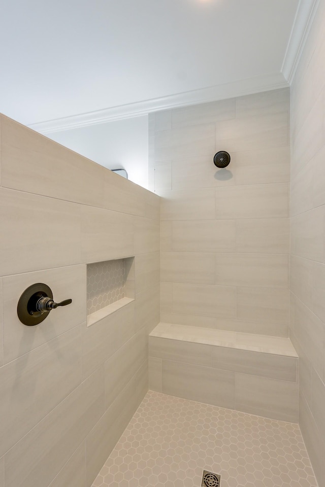 bathroom with crown molding and tiled shower