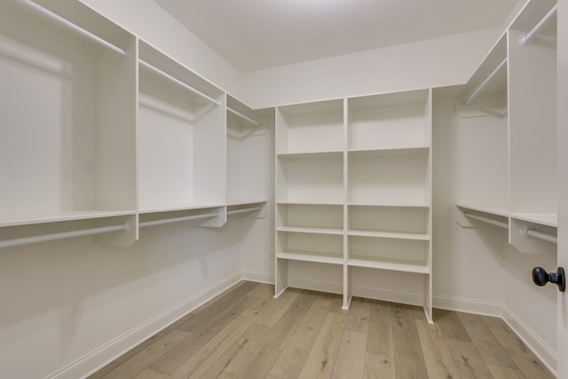 walk in closet with light hardwood / wood-style floors