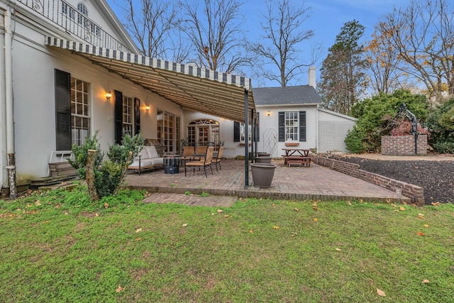 rear view of house with a patio and a lawn