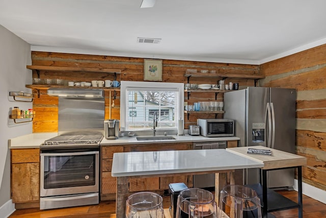 kitchen featuring a breakfast bar, sink, light wood-type flooring, a kitchen island, and stainless steel appliances