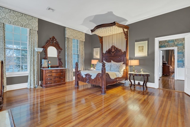 bedroom with crown molding and wood-type flooring