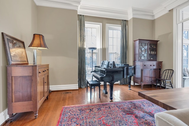 living area with light hardwood / wood-style flooring, plenty of natural light, and ornamental molding