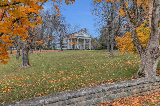 view of front of house with a balcony and a front lawn