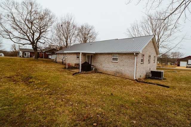 back of property featuring a lawn and central air condition unit