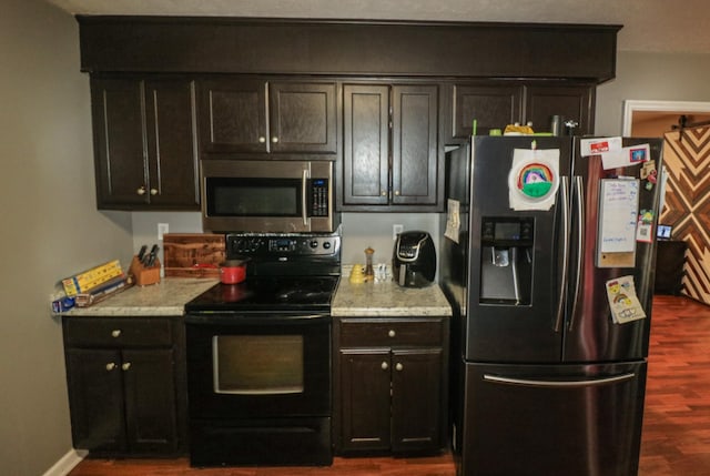 kitchen with dark brown cabinetry, dark hardwood / wood-style flooring, and stainless steel appliances