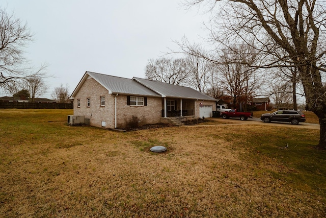 view of side of home with a garage, central AC, and a lawn