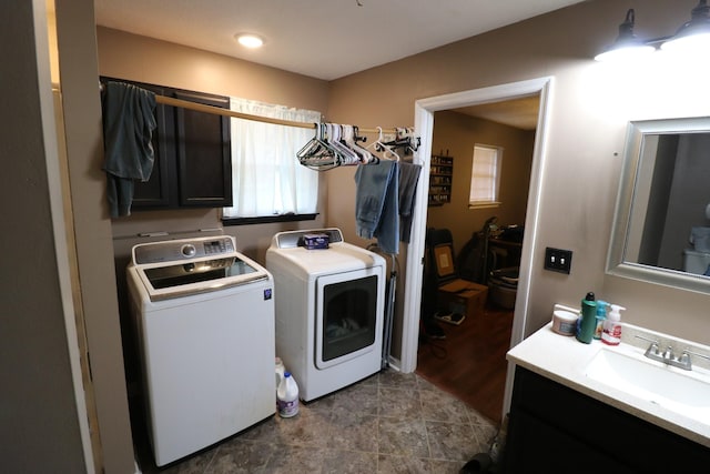 clothes washing area with cabinets, sink, and independent washer and dryer